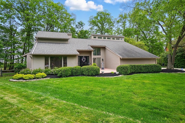 mid-century inspired home with a shingled roof and a front yard