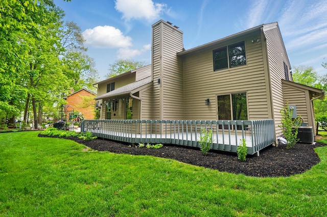 back of house featuring a wooden deck, a lawn, central air condition unit, and a chimney