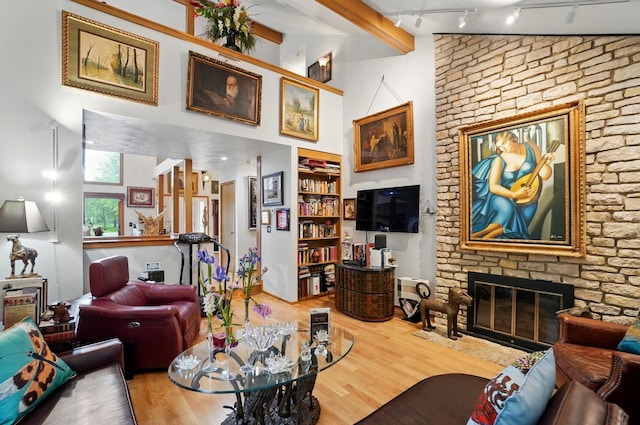 8292 Breckenridge Way, Columbus, OH 43235 - living area with wood finished floors, a large fireplace, rail lighting, built in shelves, and a high ceiling