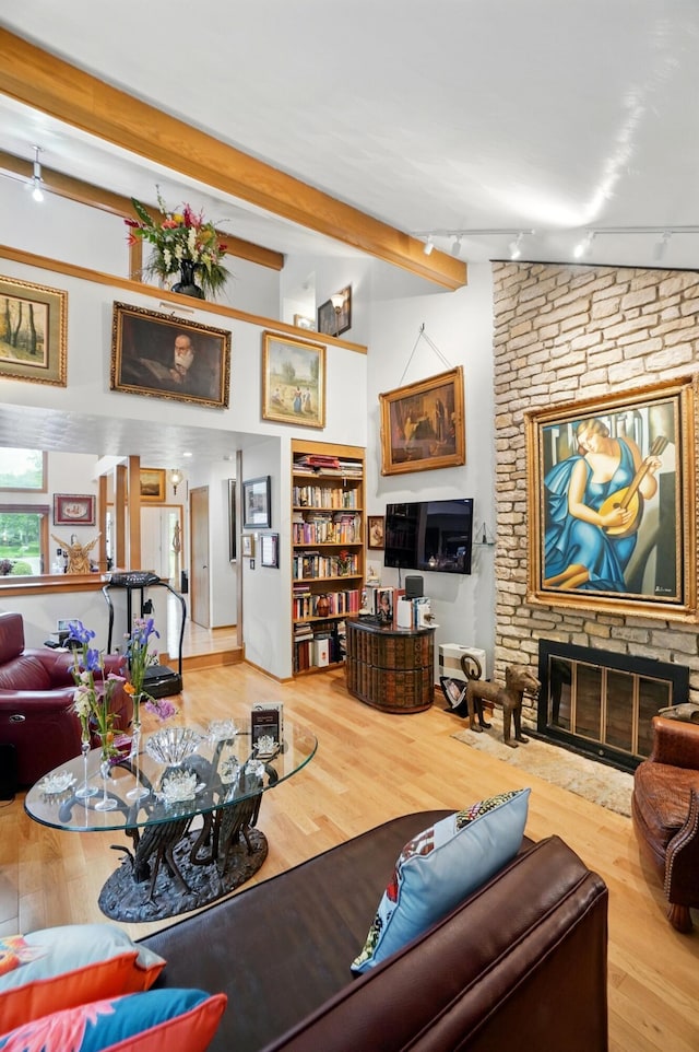 8292 Breckenridge Way, Columbus, OH 43235 - living area featuring track lighting, a fireplace, wood finished floors, and beam ceiling