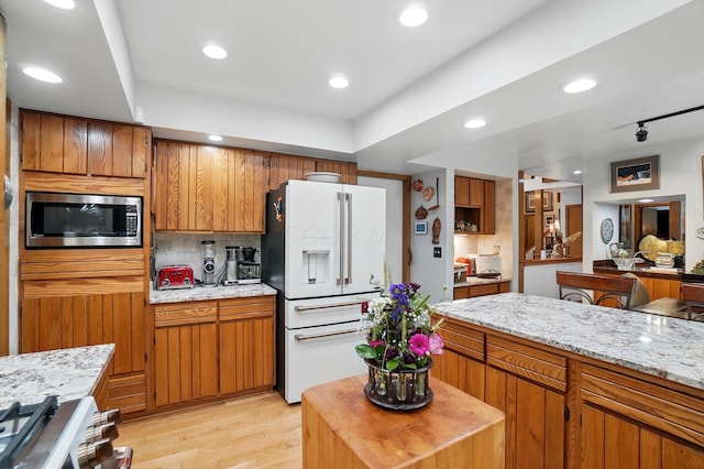 8292 Breckenridge Way, Columbus, OH 43235 - kitchen featuring appliances with stainless steel finishes, brown cabinetry, light wood-style flooring, recessed lighting, and tasteful backsplash