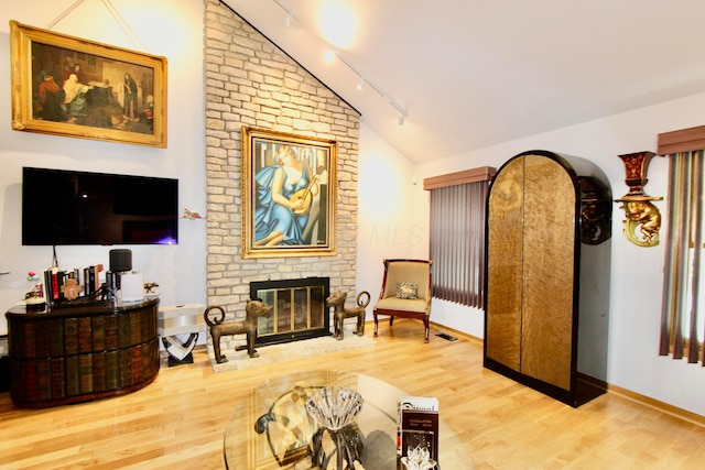 8292 Breckenridge Way, Columbus, OH 43235 - sitting room featuring rail lighting, lofted ceiling, wood finished floors, and a fireplace