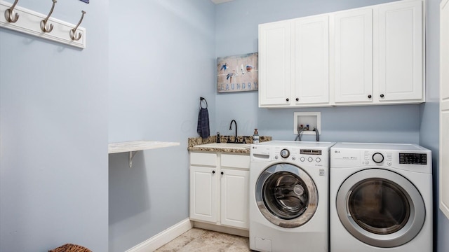 laundry area with cabinet space, washing machine and dryer, and baseboards