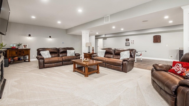 carpeted living room featuring recessed lighting, baseboards, and ornate columns