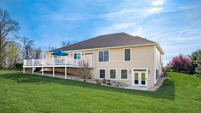 back of house featuring a deck, french doors, and a lawn