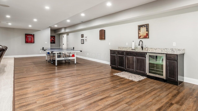 rec room with wine cooler, bar with sink, wood finished floors, recessed lighting, and baseboards