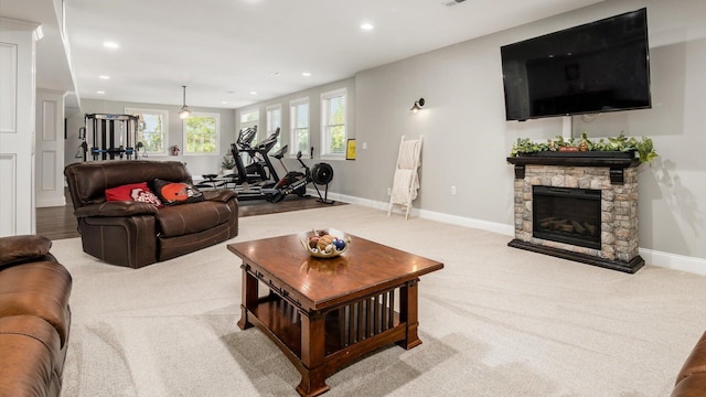 living room with a stone fireplace, light colored carpet, recessed lighting, and baseboards