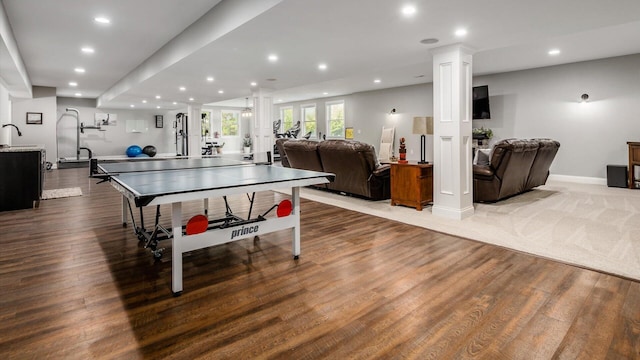 rec room featuring decorative columns, dark wood-style floors, recessed lighting, baseboards, and a sink