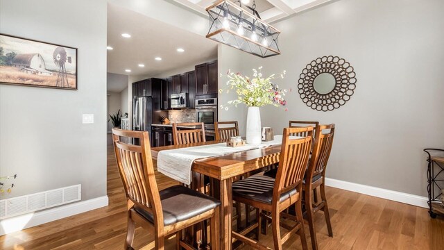 dining space featuring light wood-style floors, baseboards, and recessed lighting