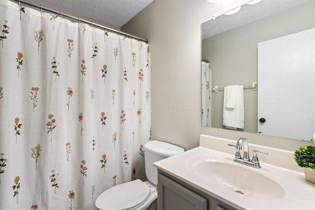 3102 Menzola Dr, Columbus, OH 43228 - bathroom with a textured ceiling, toilet, and vanity