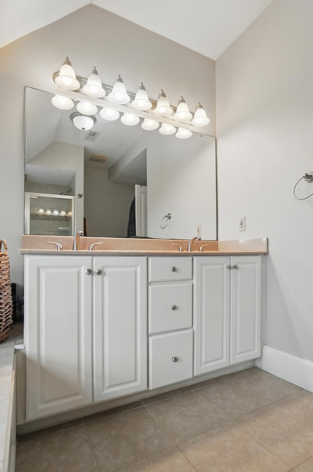 full bathroom with a shower stall, tile patterned floors, lofted ceiling, double vanity, and baseboards