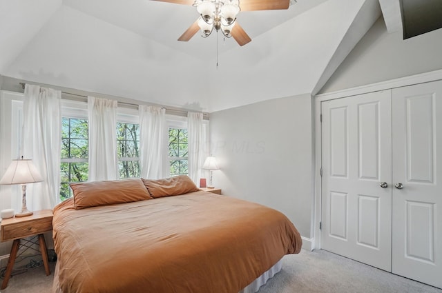 carpeted bedroom with lofted ceiling, a closet, ceiling fan, and baseboards