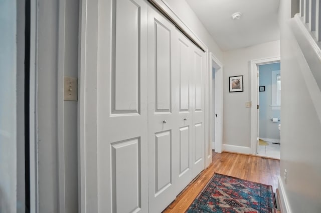 hallway with light wood-style flooring and baseboards