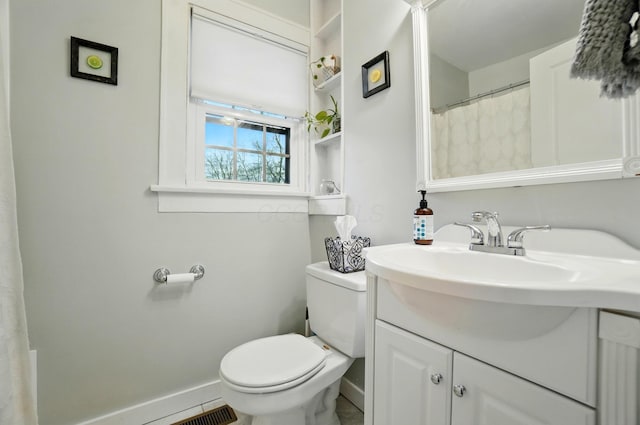 full bathroom featuring baseboards, toilet, and vanity