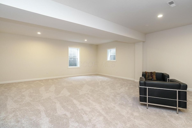 below grade area featuring baseboards and light carpet