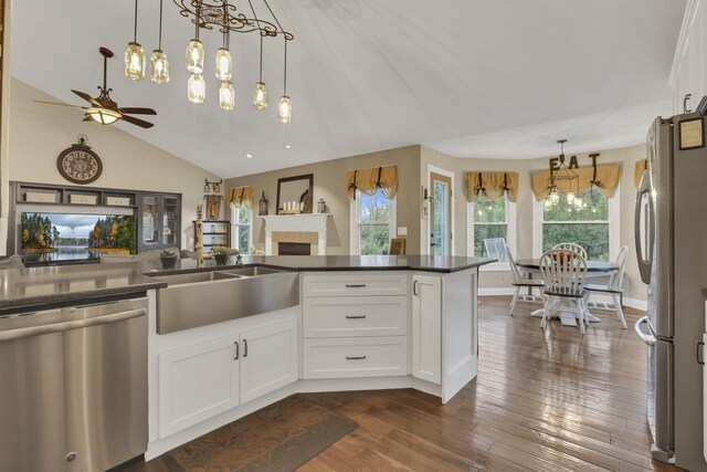 4650 Commons Park Dr, New Albany, OH 43054 - kitchen featuring appliances with stainless steel finishes, a chandelier, dark countertops, white cabinetry, and a fireplace