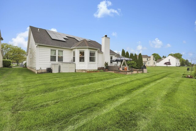 4650 Commons Park Dr, New Albany, OH 43054 - back of property with a gazebo, solar panels, a lawn, and a chimney