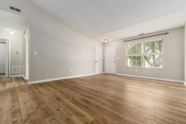 1409 Hackworth St, Columbus, OH 43207 - unfurnished living room featuring light wood finished floors, baseboards, and lofted ceiling
