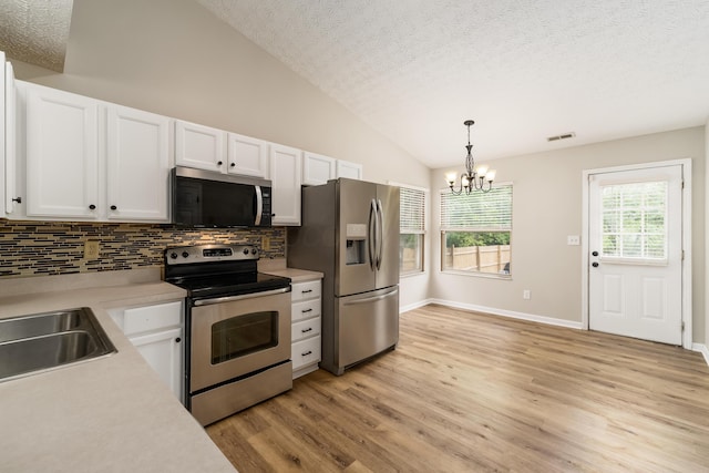 1409 Hackworth St, Columbus, OH 43207 - kitchen with appliances with stainless steel finishes, light countertops, backsplash, lofted ceiling, and white cabinets