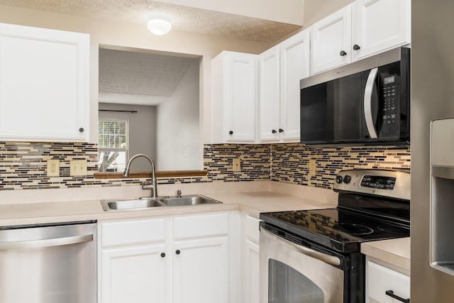 1409 Hackworth St, Columbus, OH 43207 - kitchen with appliances with stainless steel finishes, a sink, light countertops, backsplash, and a textured ceiling