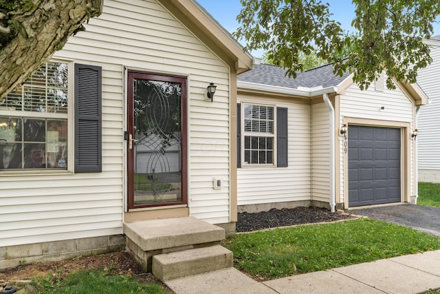 1409 Hackworth St, Columbus, OH 43207 - entrance to property featuring a shingled roof, an attached garage, and asphalt driveway