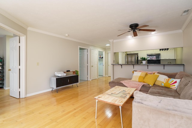 living room with ceiling fan, crown molding, light wood-type flooring, and visible vents