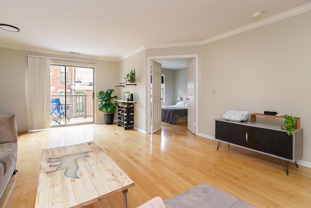 living room featuring baseboards, crown molding, and light wood-type flooring