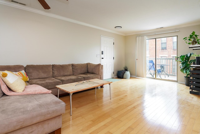 living area featuring baseboards, ornamental molding, light wood finished floors, ceiling fan, and visible vents
