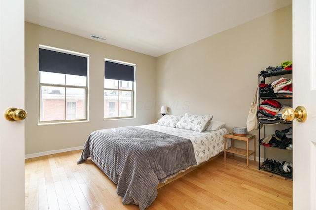 bedroom featuring visible vents, wood finished floors, and baseboards