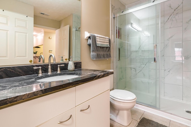 full bath with toilet, visible vents, a shower stall, tile patterned flooring, and vanity