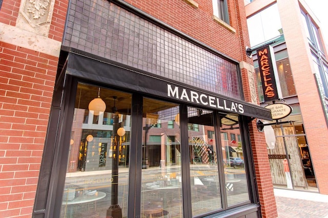 view of exterior entry featuring brick siding