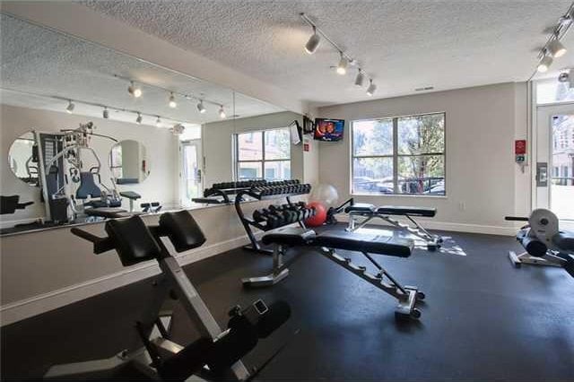 workout area with baseboards, a textured ceiling, and track lighting