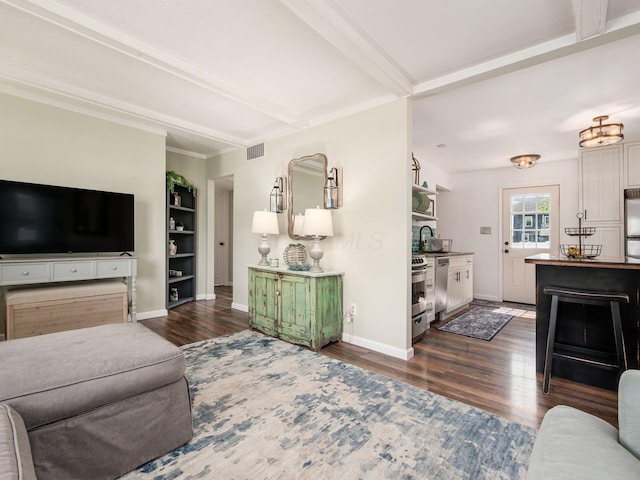 5349 Norwich St, Hilliard, OH 43026 - living room featuring dark wood-style floors, beamed ceiling, baseboards, and built in shelves