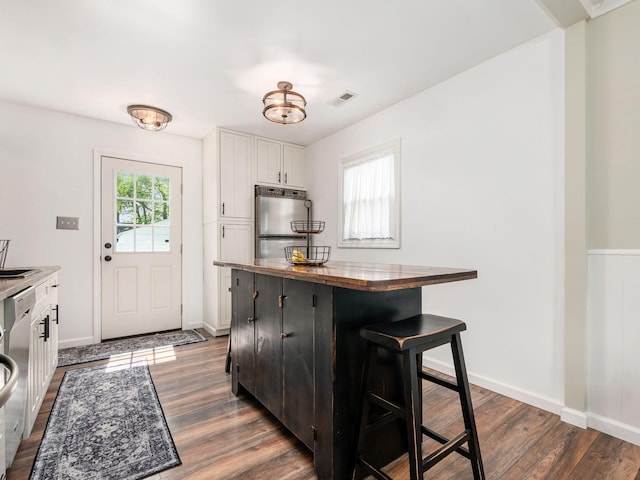5349 Norwich St, Hilliard, OH 43026 - kitchen with stainless steel appliances, white cabinetry, dark wood-type flooring, a breakfast bar area, and butcher block countertops