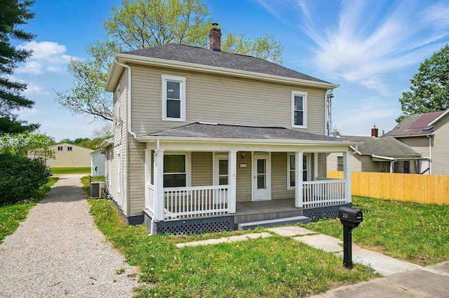 view of front facade with a porch, fence, cooling unit, and a chimney