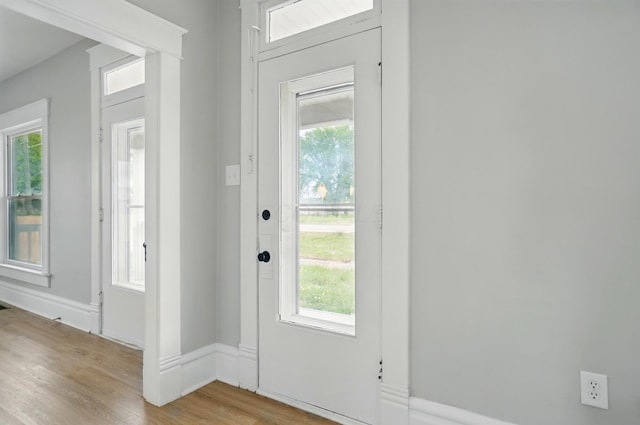 entryway featuring baseboards, a wealth of natural light, and light wood-style floors