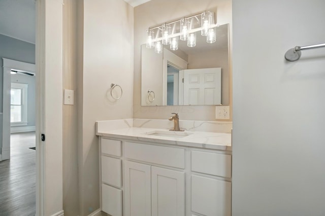 bathroom featuring baseboards, vanity, and wood finished floors