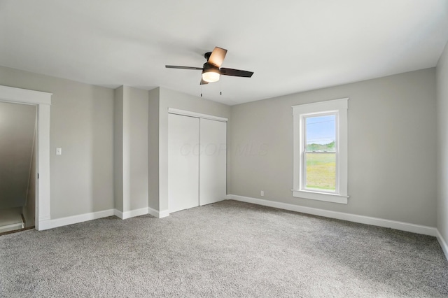 unfurnished bedroom with carpet, a closet, and baseboards
