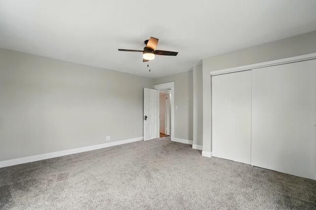 unfurnished bedroom featuring a closet, baseboards, ceiling fan, and carpet floors