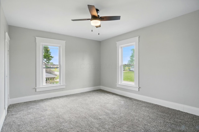 carpeted empty room featuring plenty of natural light, baseboards, and ceiling fan