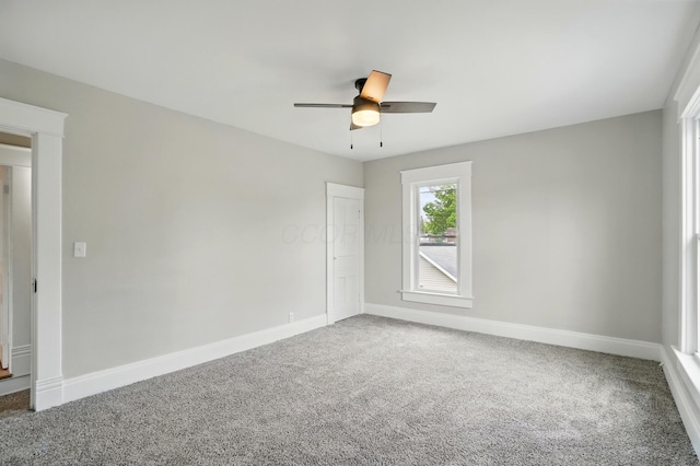spare room featuring baseboards, ceiling fan, and carpet floors