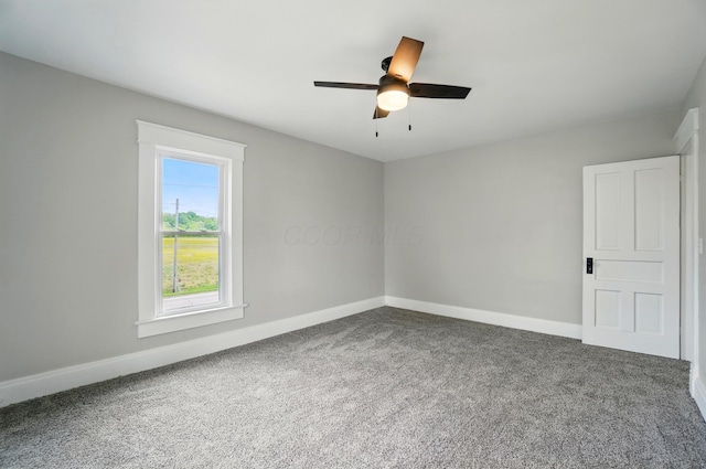 carpeted empty room featuring ceiling fan and baseboards