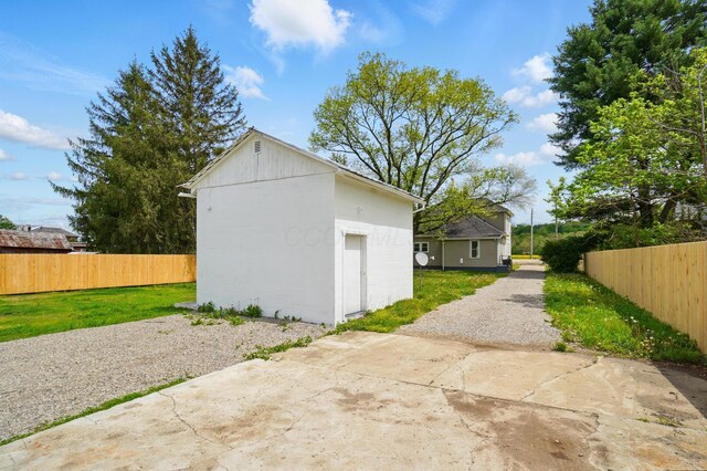 view of outbuilding featuring an outdoor structure and fence