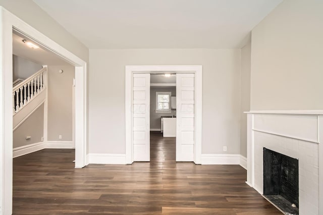 96 S Eureka Ave, Columbus, OH 43204 - unfurnished living room with dark wood-style flooring, baseboards, and a fireplace
