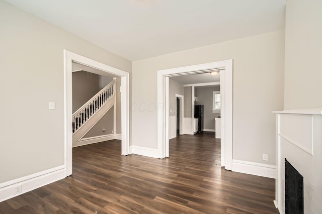 96 S Eureka Ave, Columbus, OH 43204 - unfurnished living room featuring stairs, baseboards, dark wood-style floors, and a fireplace