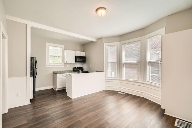 96 S Eureka Ave, Columbus, OH 43204 - kitchen with black appliances, white cabinetry, dark wood-style flooring, a peninsula, and light countertops