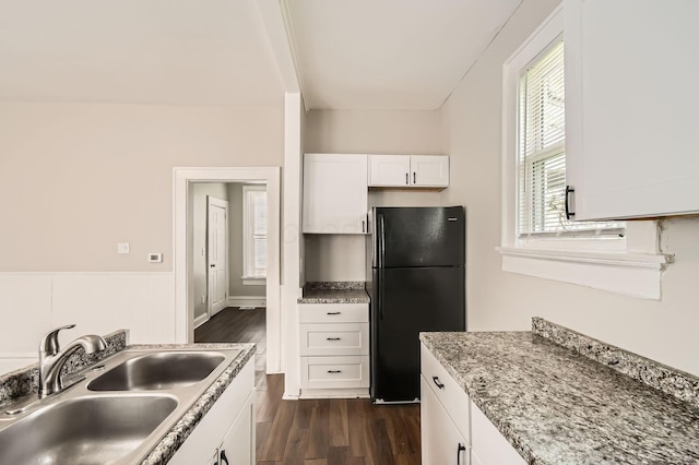 96 S Eureka Ave, Columbus, OH 43204 - kitchen with freestanding refrigerator, a sink, dark wood finished floors, white cabinetry, and a wainscoted wall
