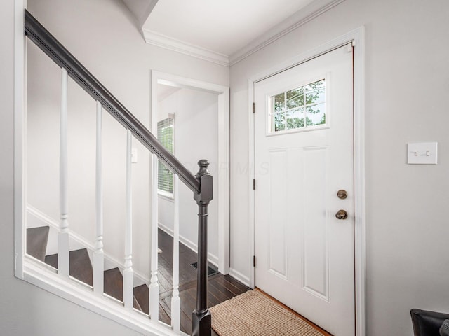 entryway with stairway, wood finished floors, and ornamental molding
