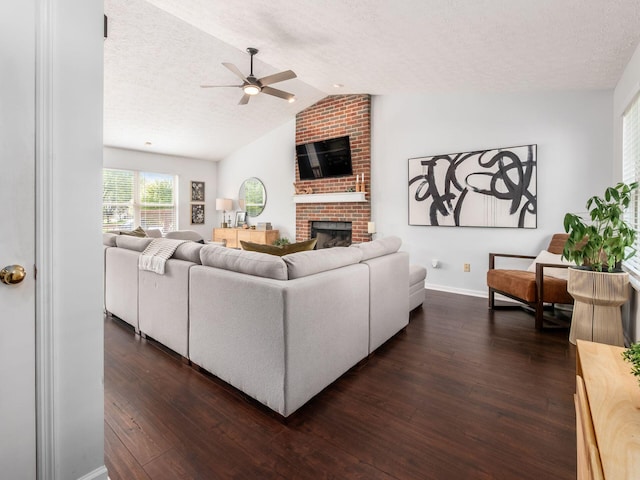 2284 Brisum Way, Hilliard, OH 43026 - living room featuring ceiling fan, dark wood-type flooring, lofted ceiling, a fireplace, and a textured ceiling