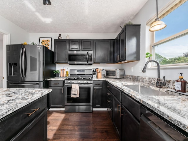 2284 Brisum Way, Hilliard, OH 43026 - kitchen with appliances with stainless steel finishes, a sink, light stone counters, dark wood-style floors, and a textured ceiling